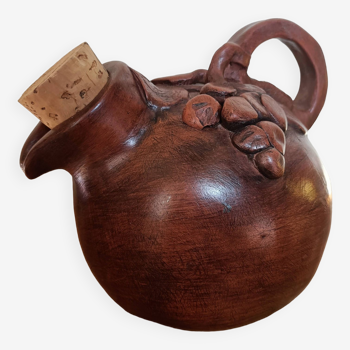 Wine pitcher with cork stopper and bunch of grapes decoration