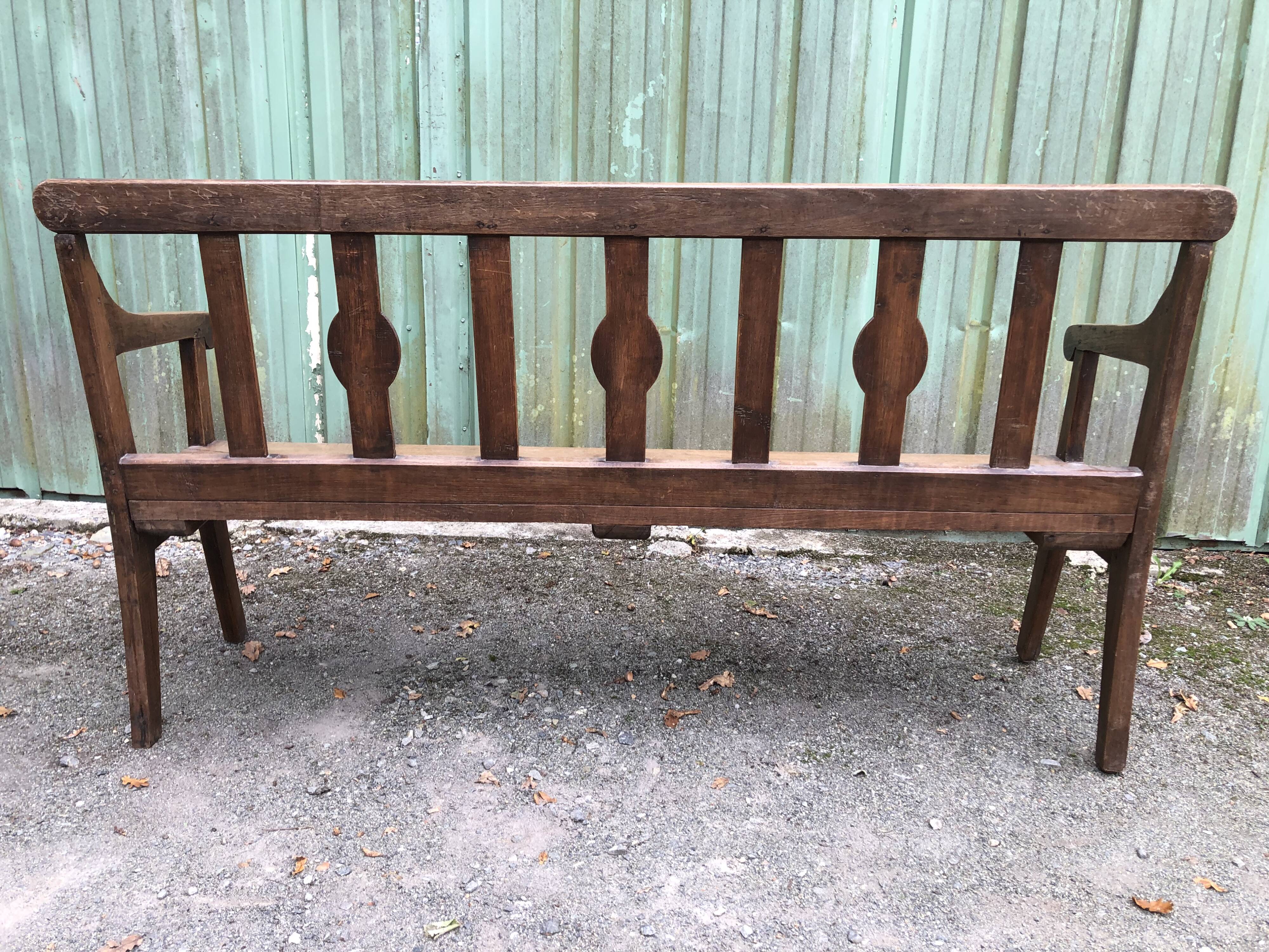 Duo of old solid oak benches with backs and armrests.