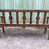 Duo of old solid oak benches with backs and armrests.