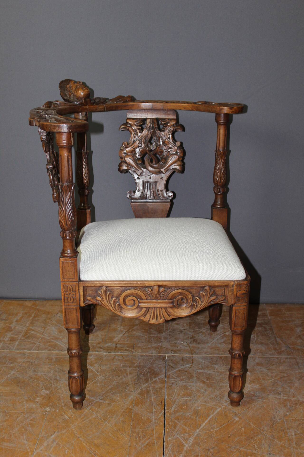 19th century walnut corner armchair with carved angel decoration