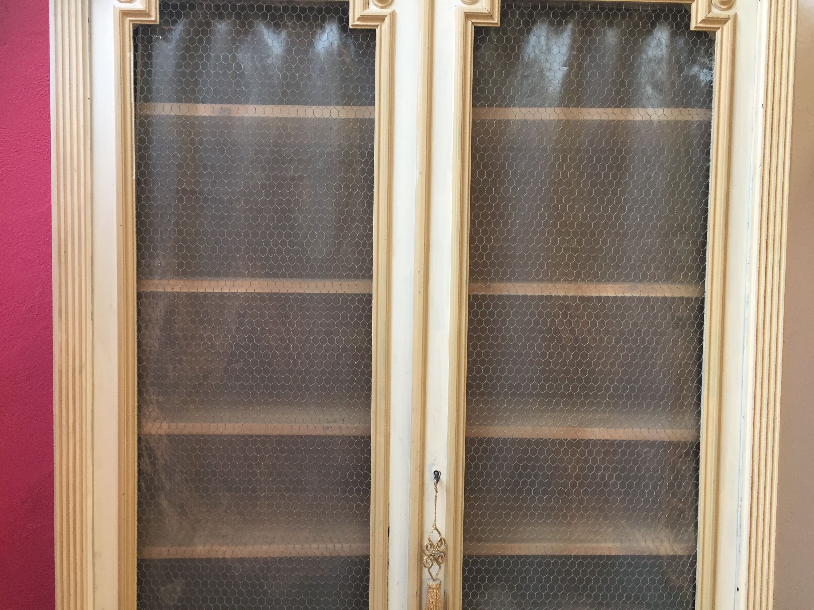 Bookcase 2 painted in ochre and cream mesh doors beginning 20 th