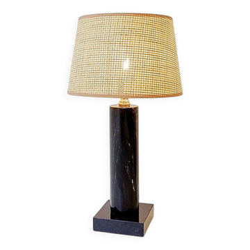 Black marble table lamp with natural raffia shade.