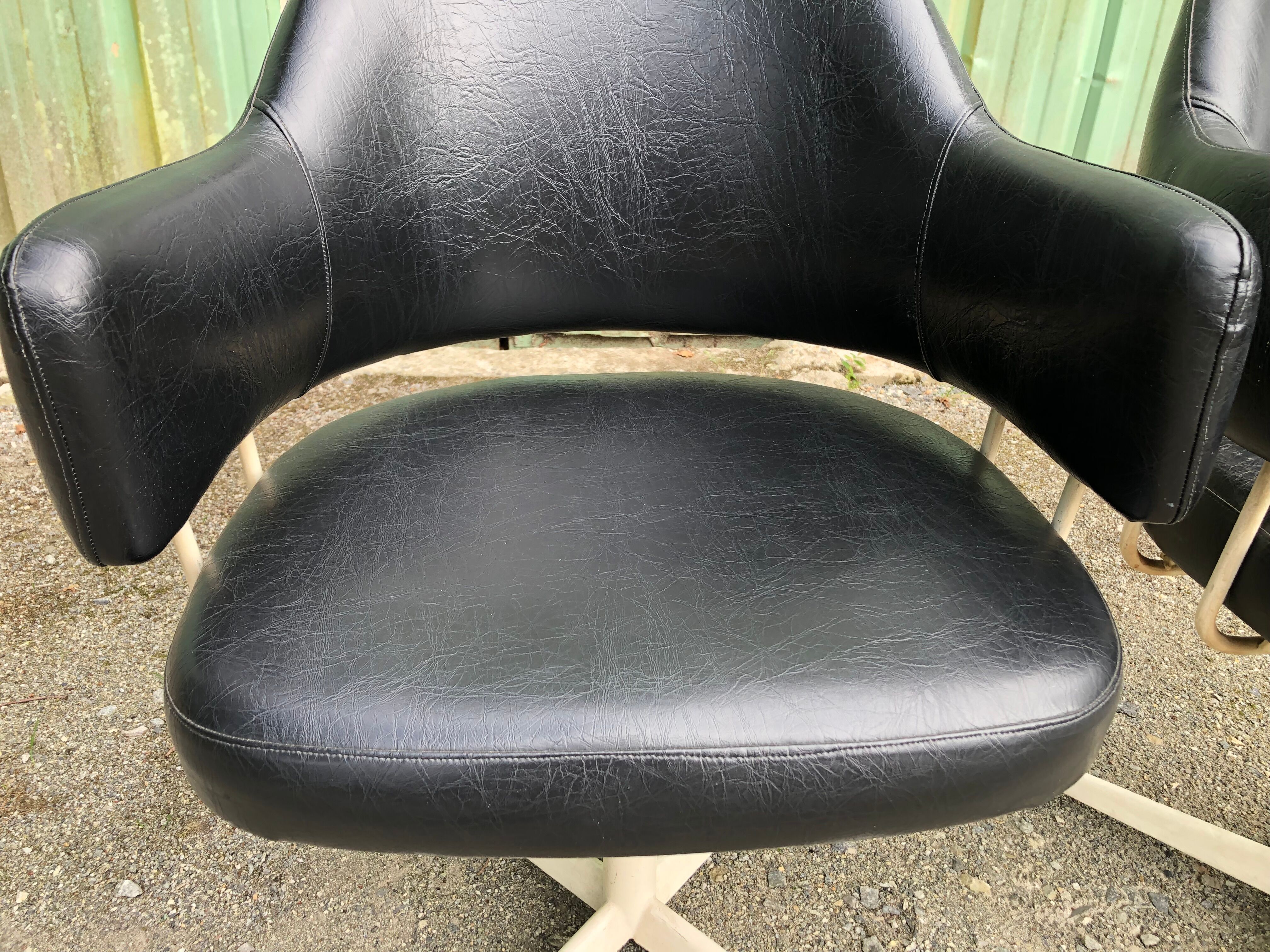 Pair of vintage armchairs in black skai with metal legs.