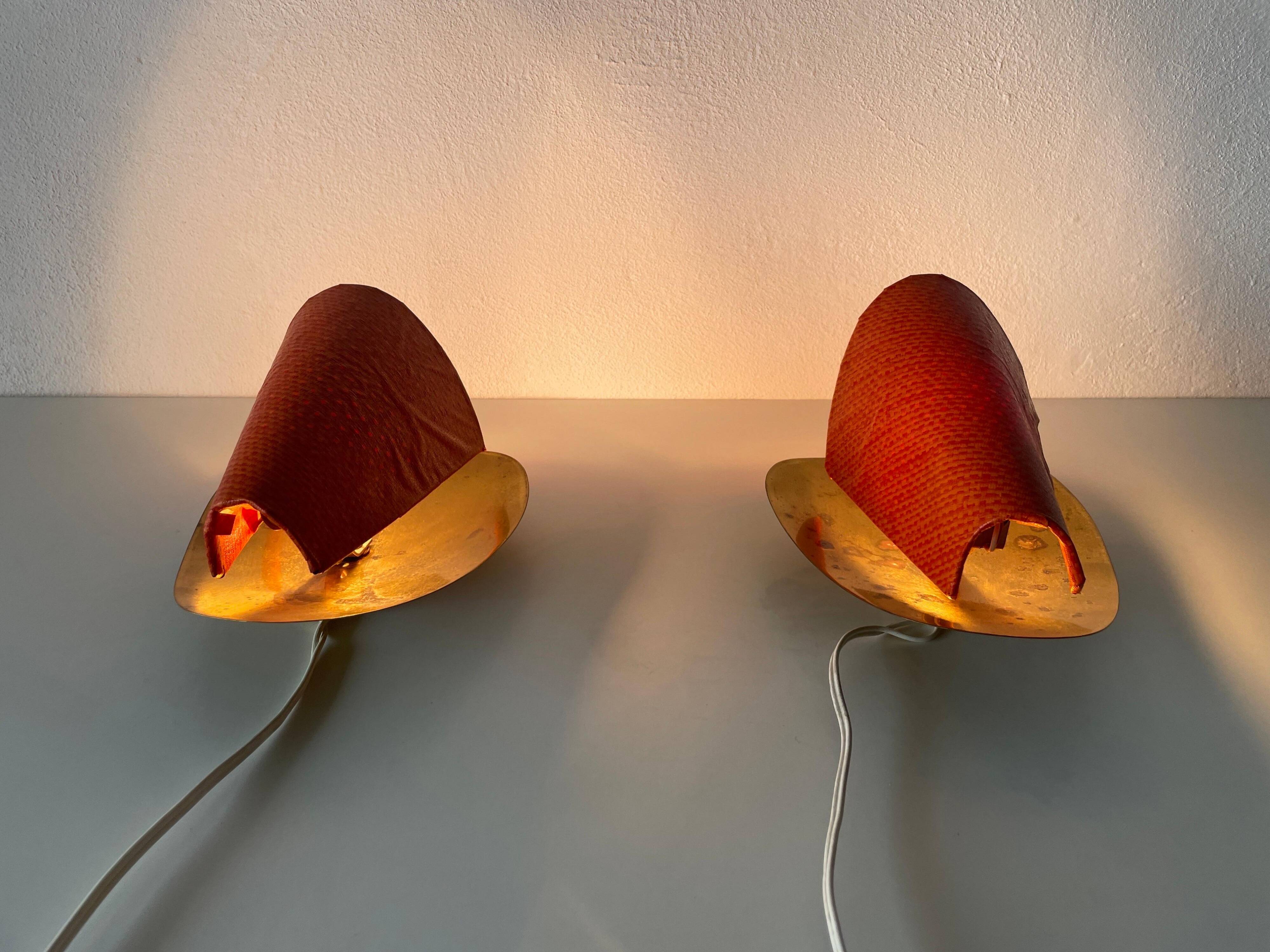 Pair of orange plexiglass and curved brass wall lights, 1950s, Germany
