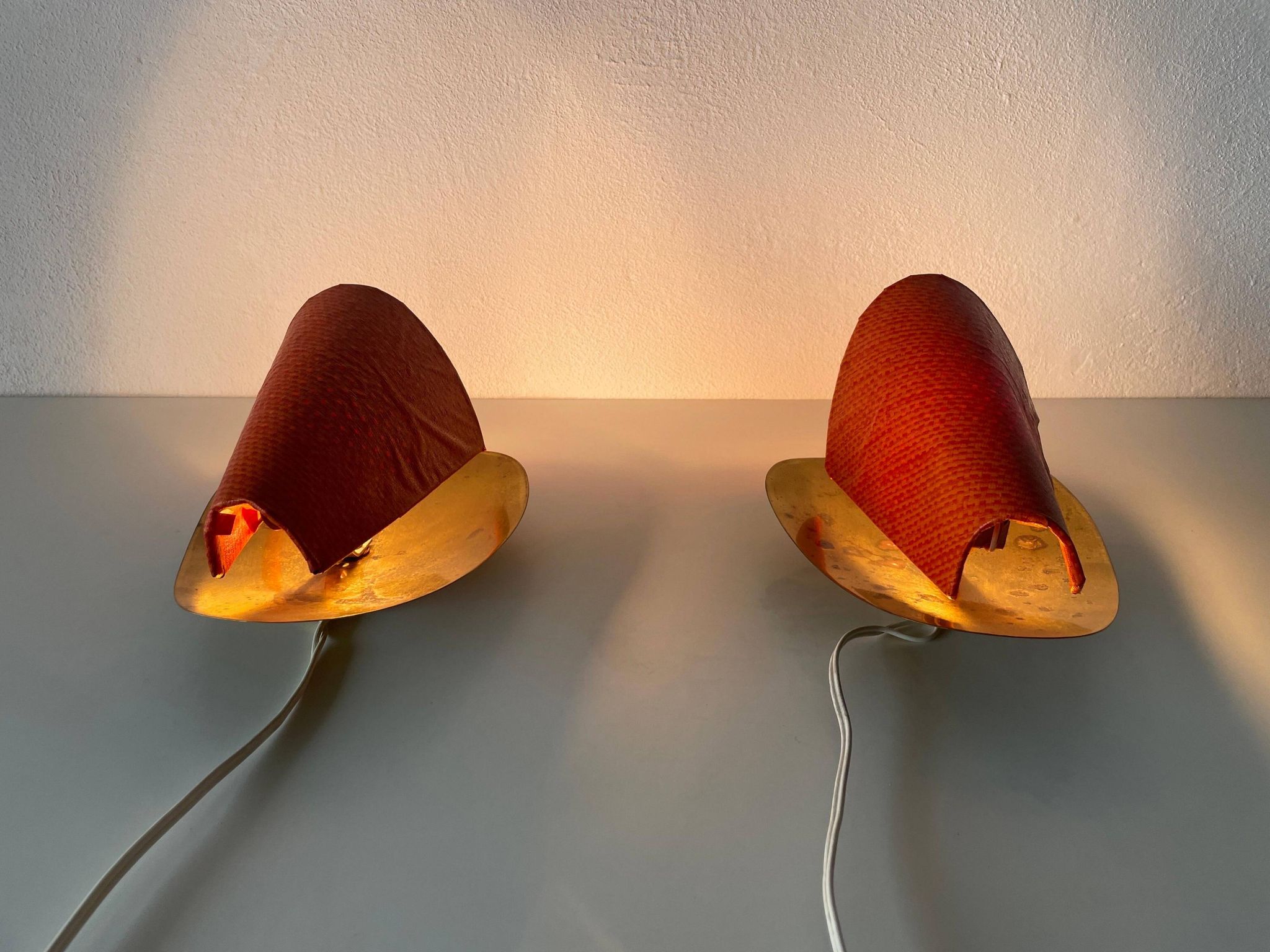 Pair of orange plexiglass and curved brass wall lights, 1950s, Germany