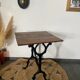 Bistro table with iron legs and raw wood top.
