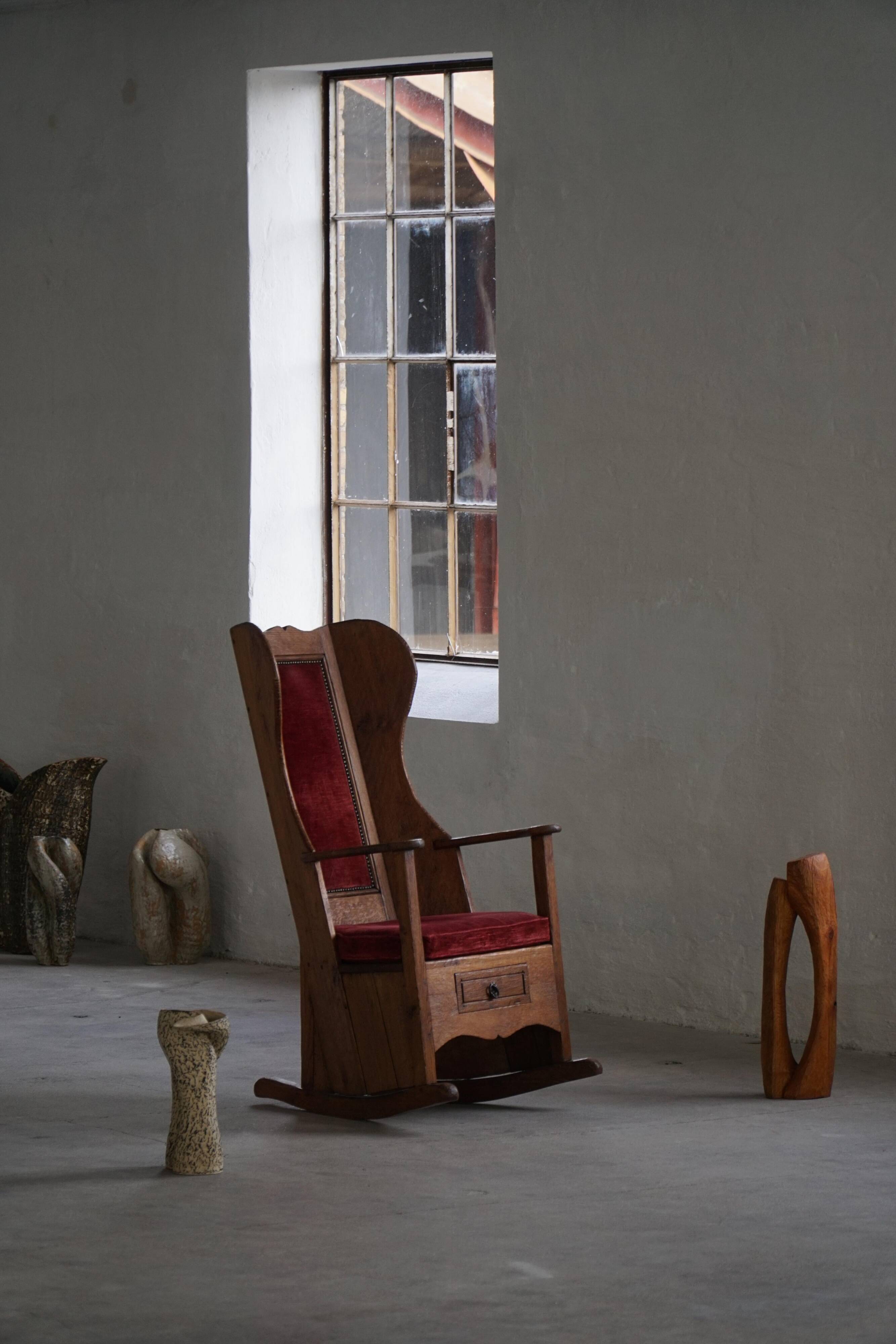 Antique English rocking chair in wood with red velvet upholstery, 19th century.