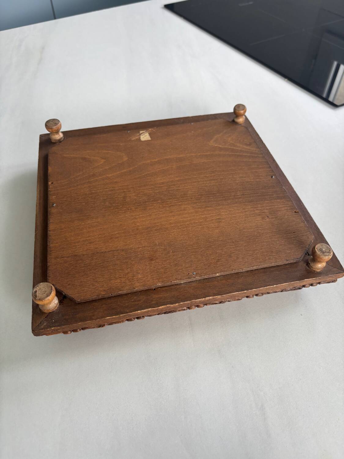 Vintage wooden and antique earthenware trivet, brown tile design