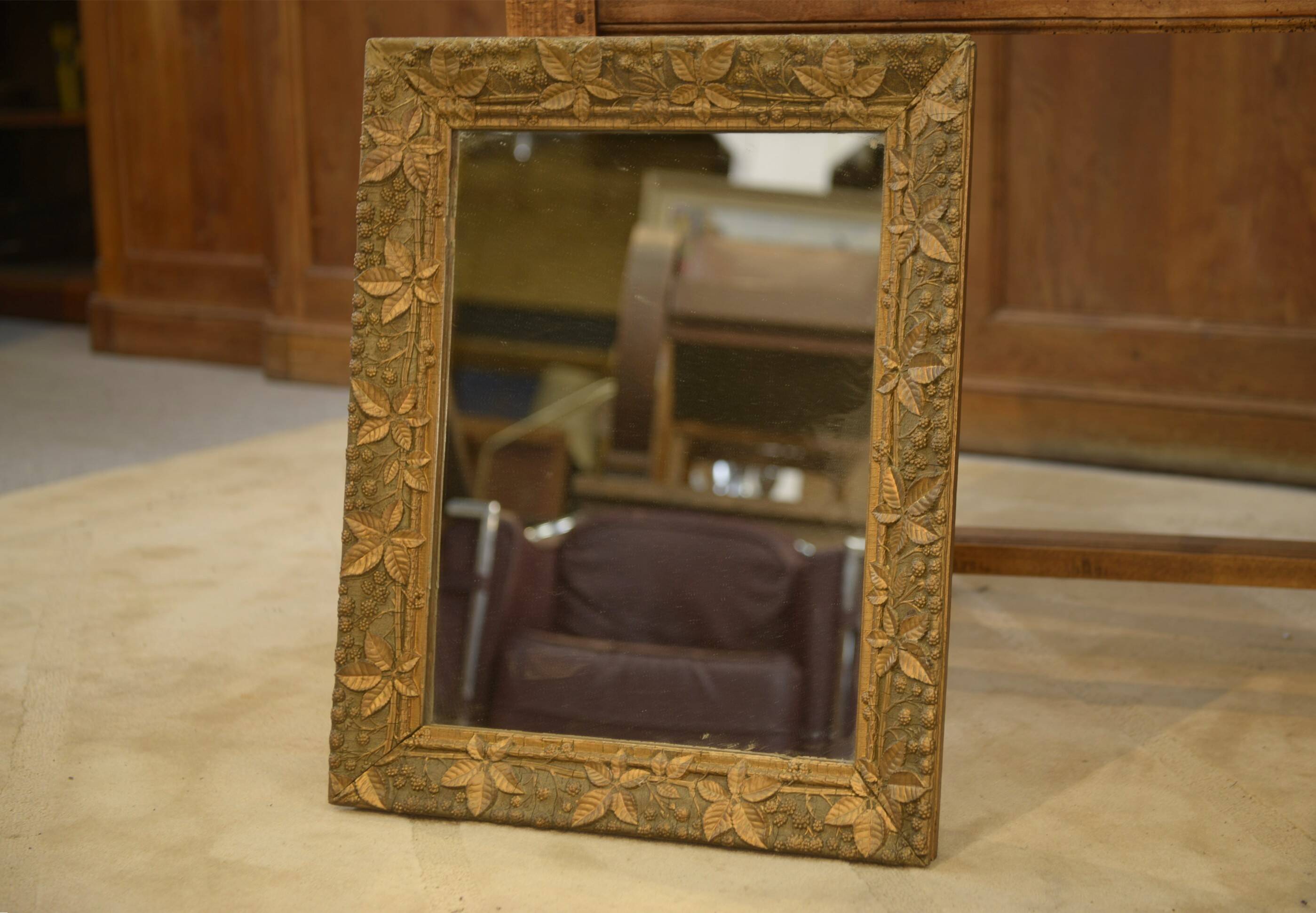 19th-century mirror in wood and stucco with floral decoration.