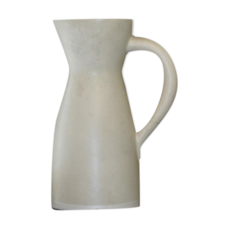 White ceramic pitcher with yellow background