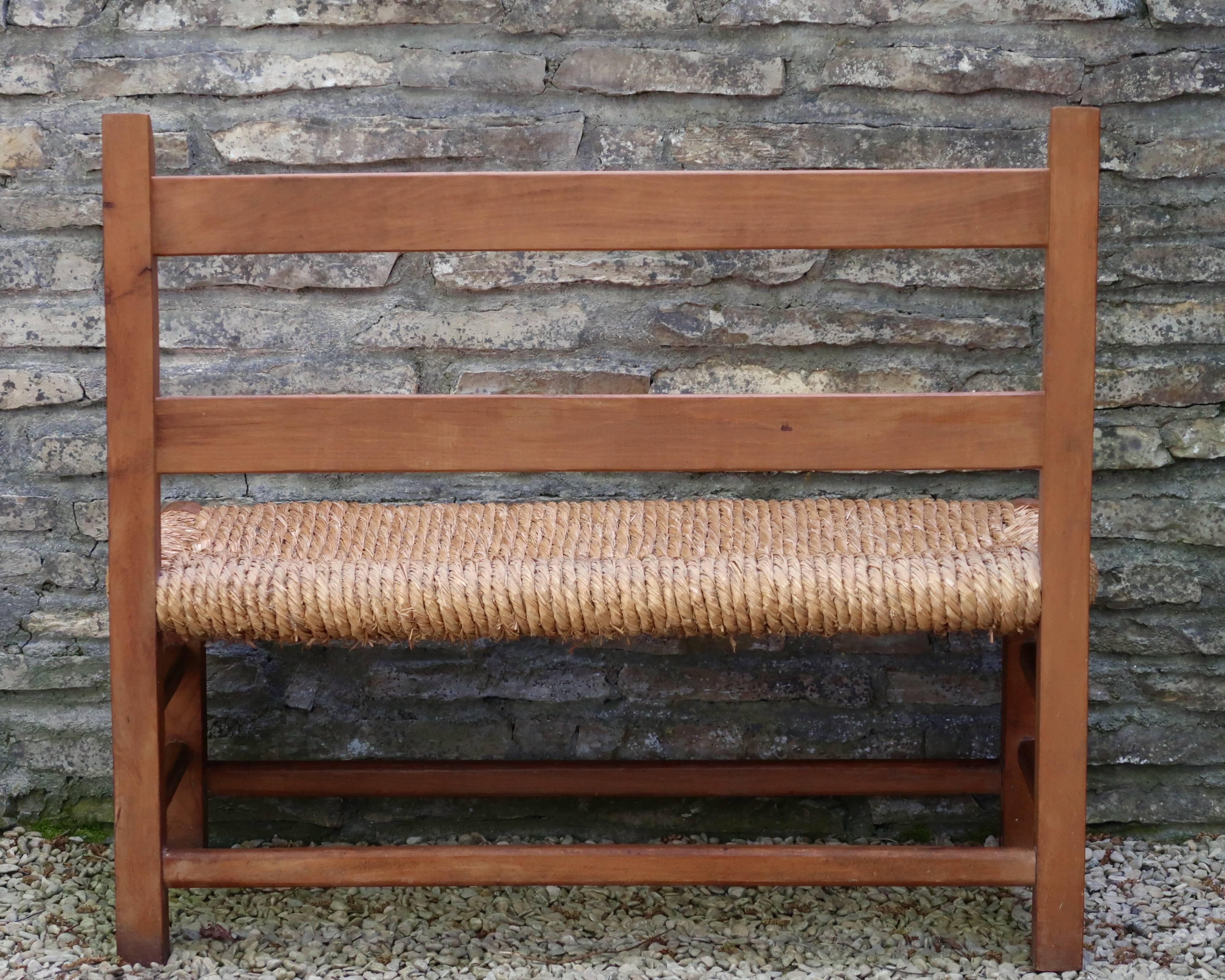 Wooden-backed bench with straw seat, 1970s.