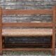 Wooden-backed bench with straw seat, 1970s.