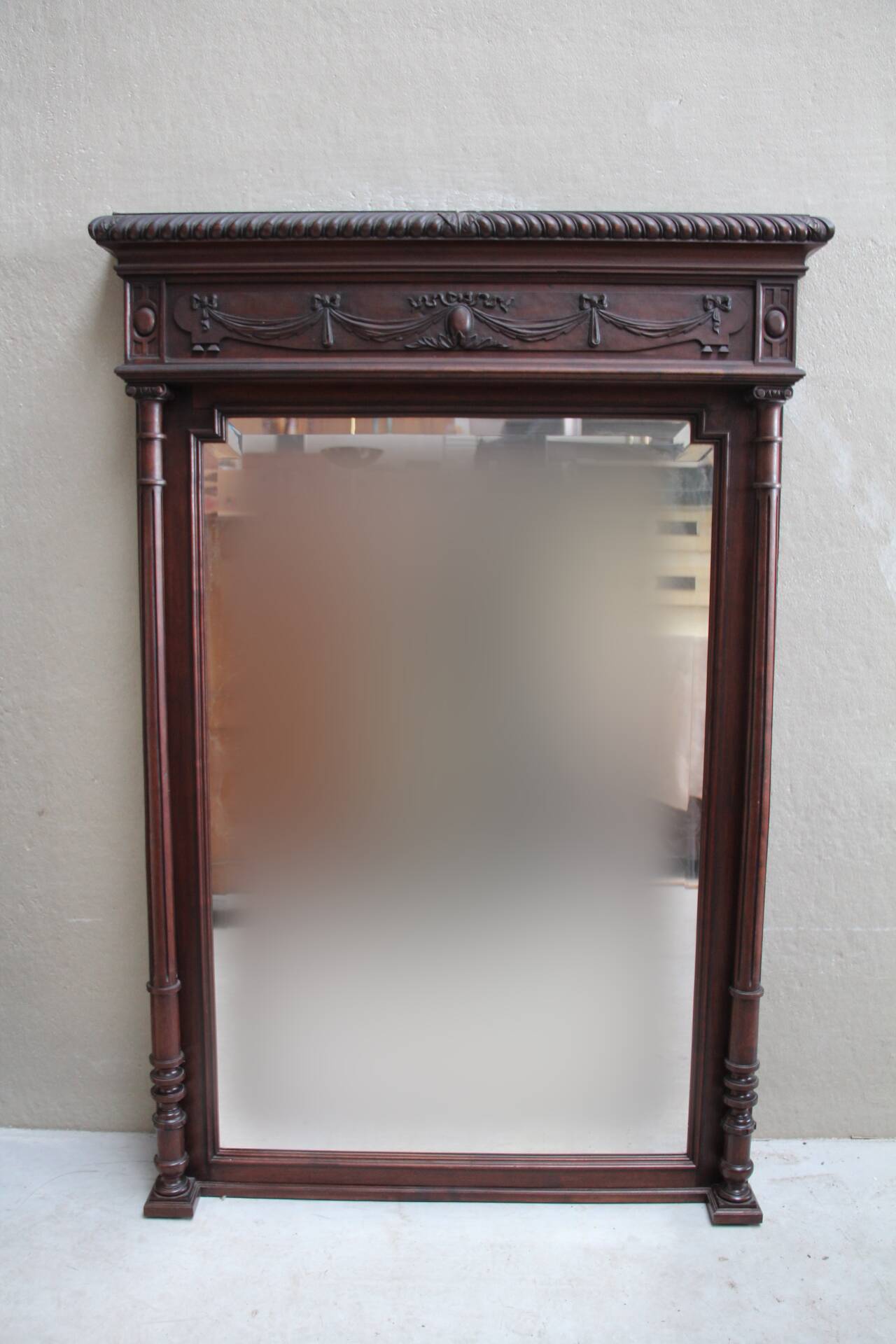 Imposing beveled mirror with wooden frame