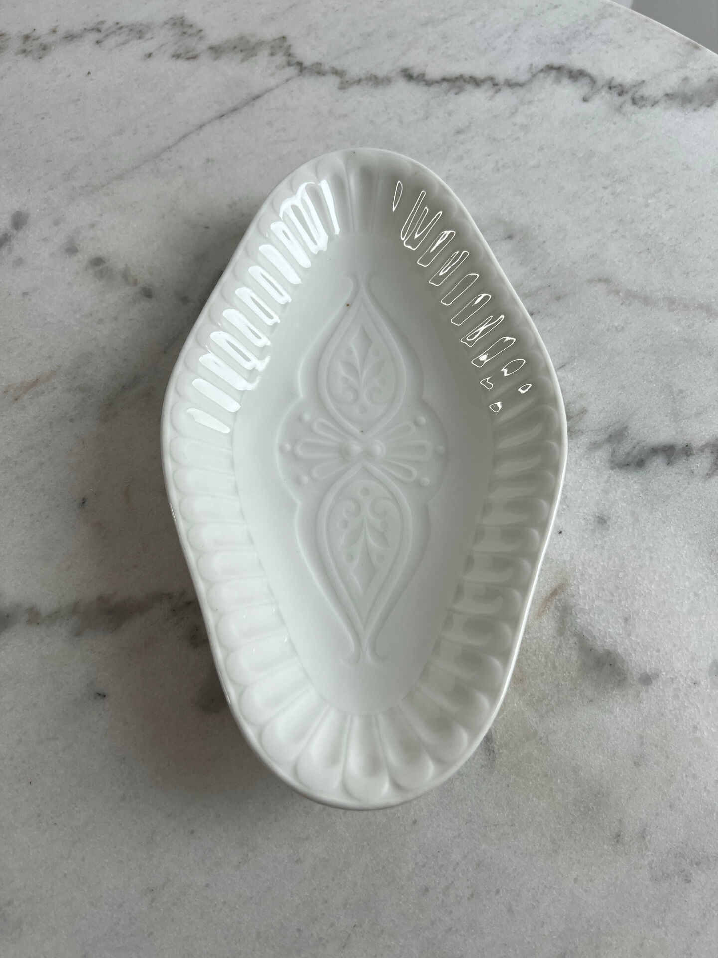 Oval white porcelain ramekin — raised floral pattern