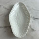 Oval white porcelain ramekin — raised floral pattern