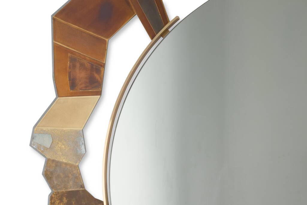 Contemporary mirror in oxidized bronze and brass with a deconstructed shape.