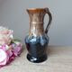 Vintage 1960s brown and blue flame-patterned stoneware wine jug carafe.