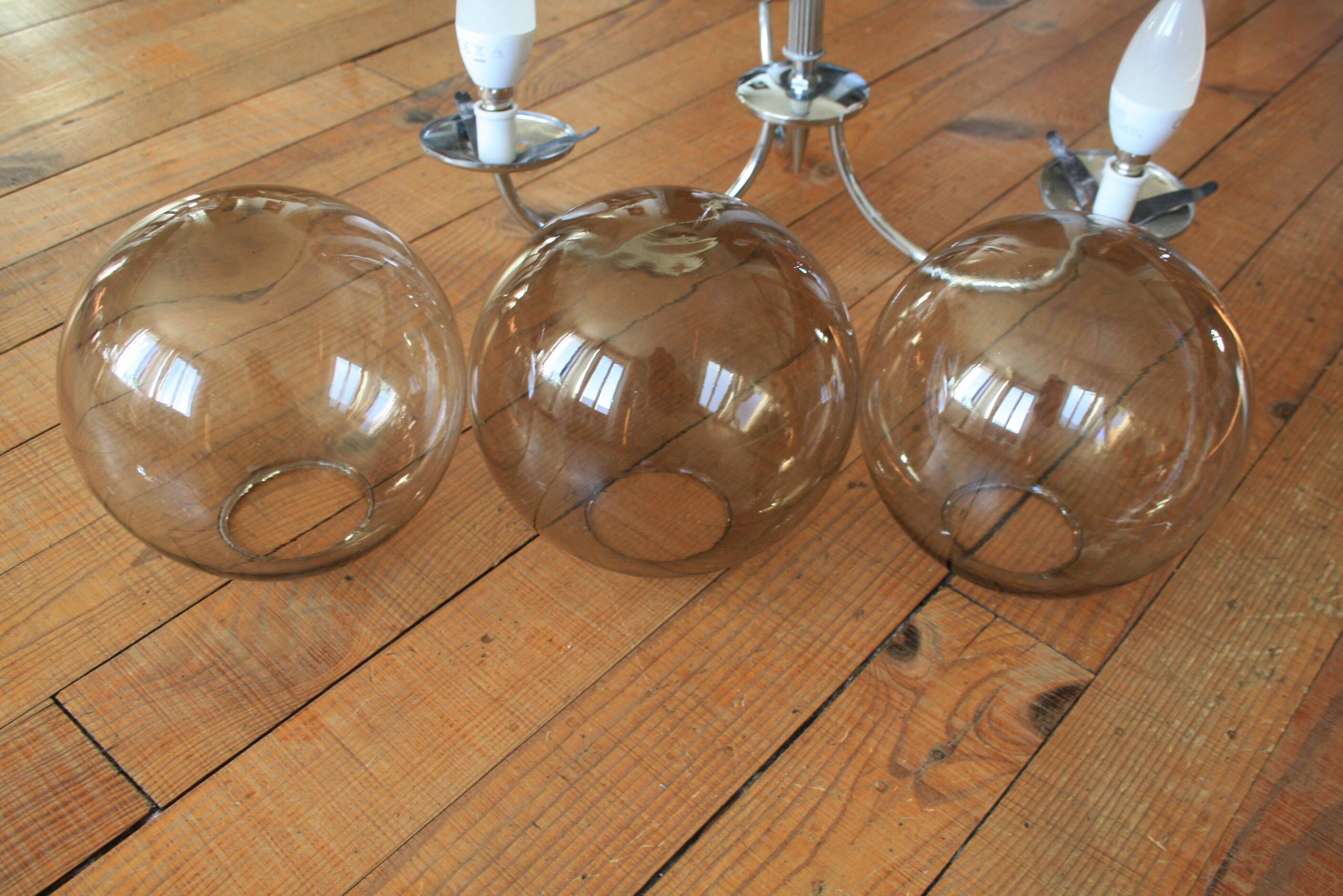 Chrome metal chandelier with smoked glass globes.