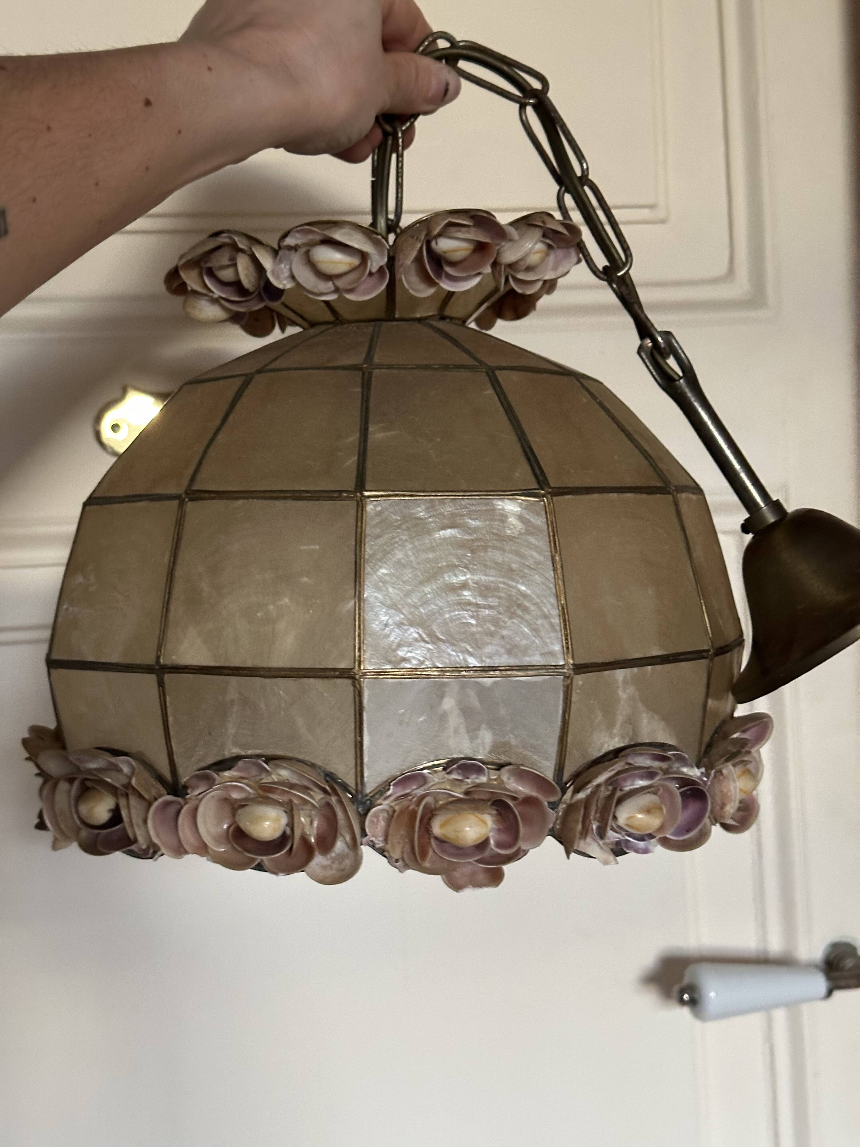 Vintage pendant light with a pearlescent shade and floral decoration.