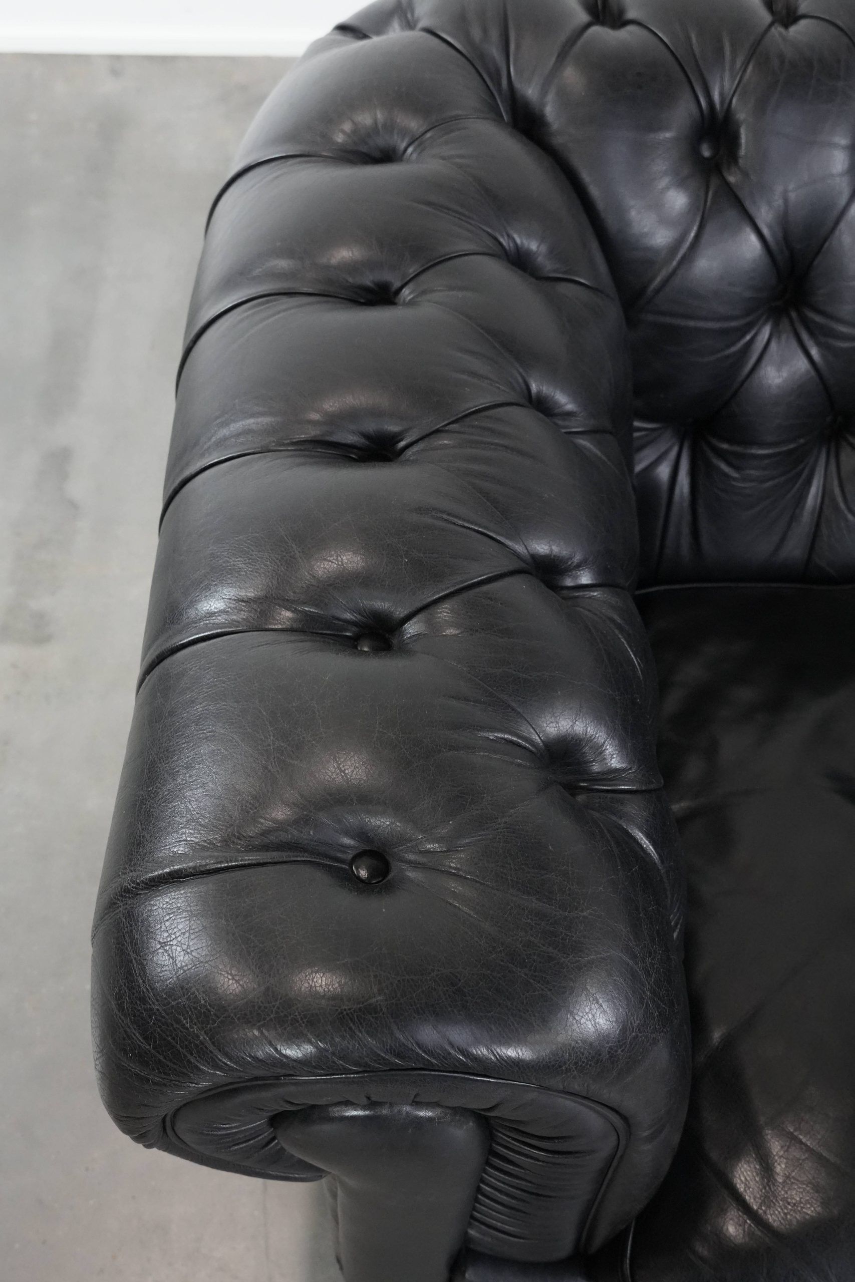 Comfortable black chesterfield armchair made of cowhide leather