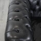 Comfortable black chesterfield armchair made of cowhide leather