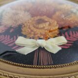 Dried flowers under curved glass frame
