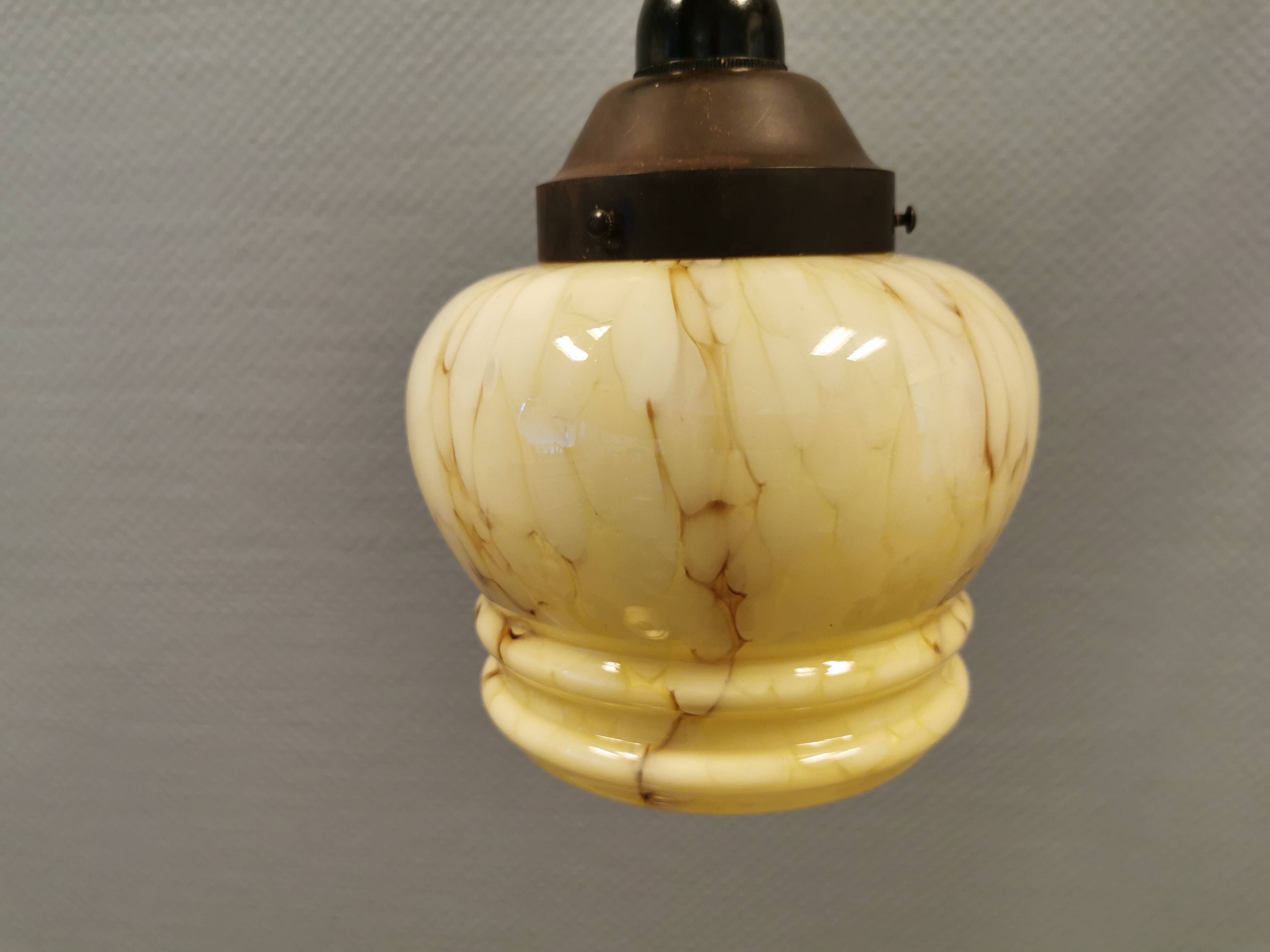 Small Art Deco hanging lamp in cream colored glass with bakelite top. Estimated 1950s