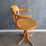 Old swivel office armchair in curved wood