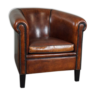 Fauteuil club en cuir de mouton avec passepoil noir et clous décoratifs