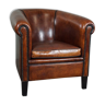 Sheepskin club chair with black piping and decorative studs