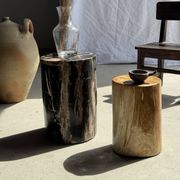 Black petrified wood side table with beige stripes and a semicircular shape.