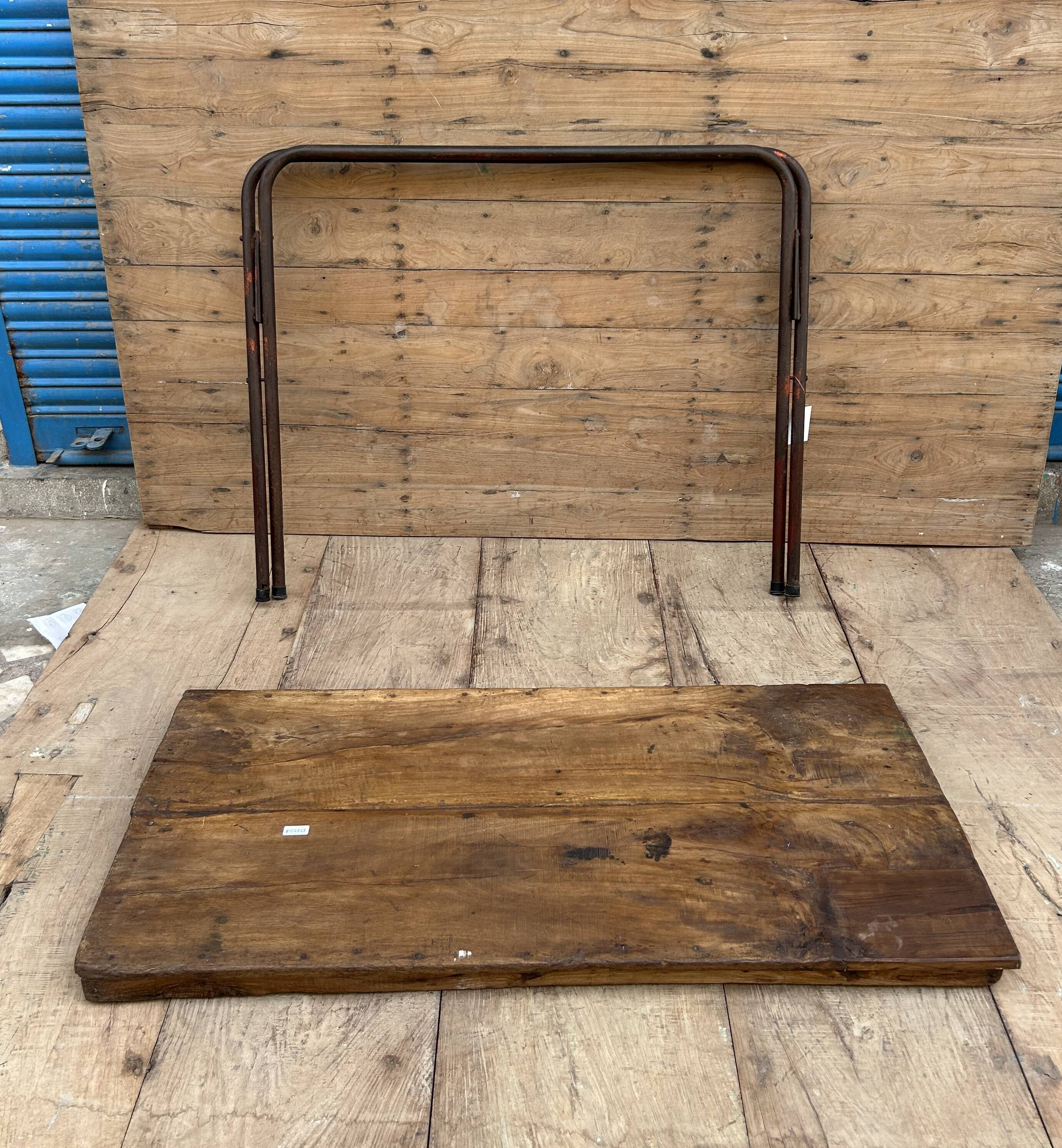 Folding workshop table with a metal frame and solid teak top.