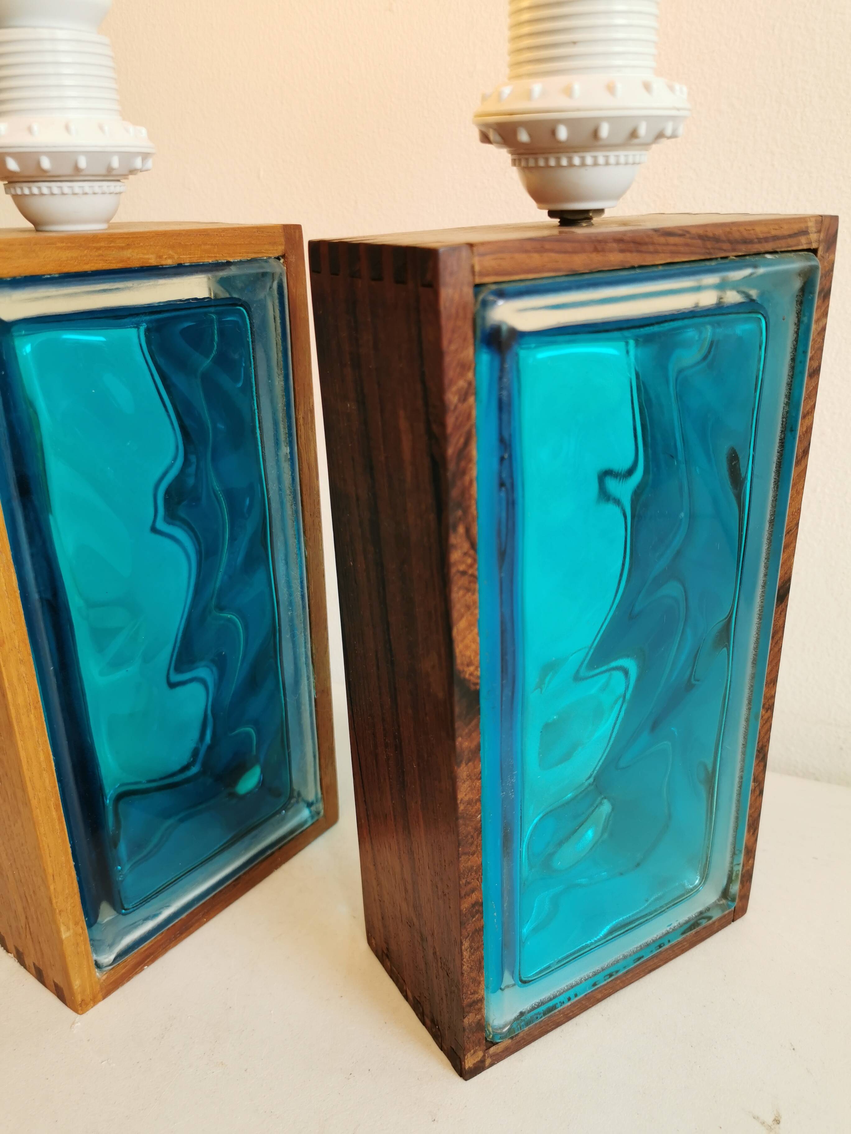 Two Swedish table lamps in solid pressed blue glass and teak wood "frame".