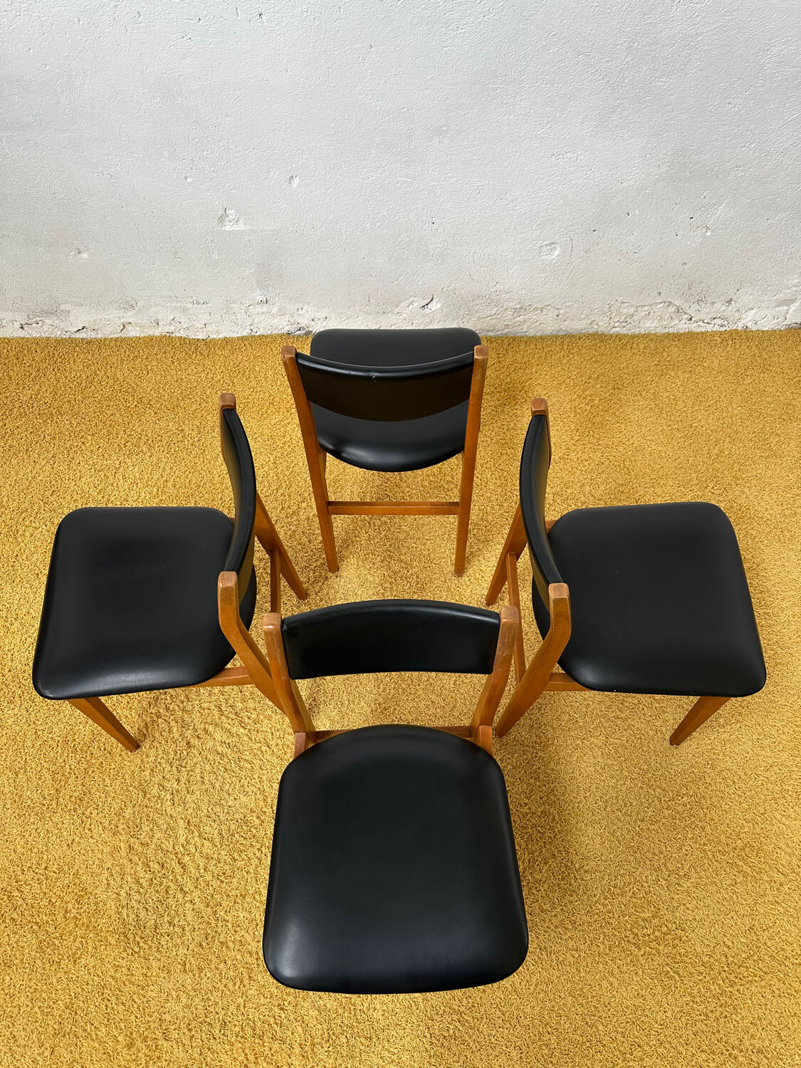 4 Scandinavian chairs in teak and black faux leather.
