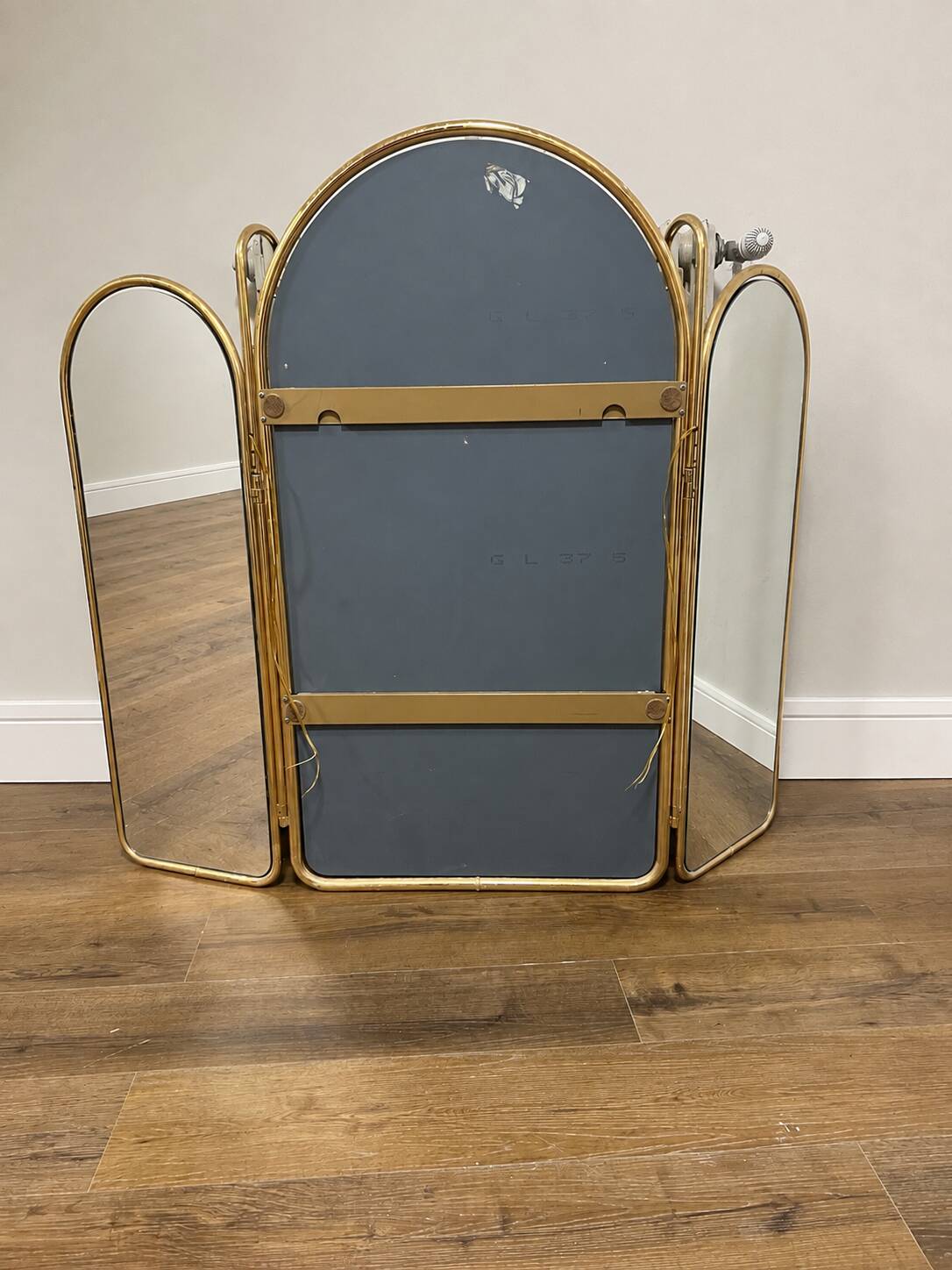 Vintage triptych mirror in brass with wall lights.