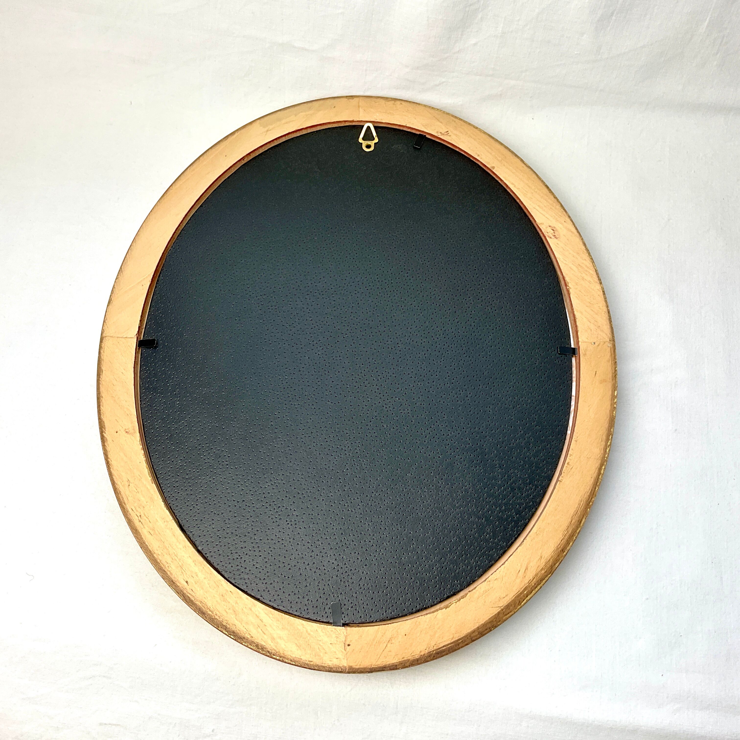 Old oval gilded wooden frame with domed glass
