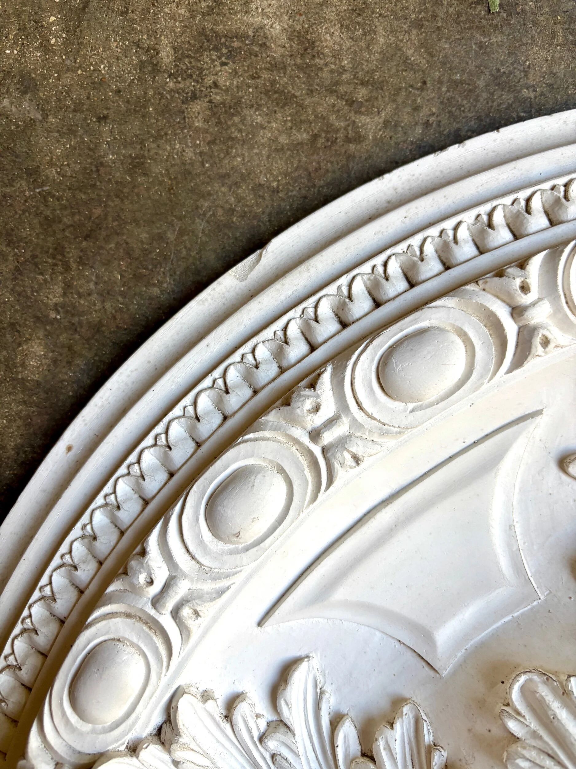 Rosette on white background, decorated with scrolls and beaded frieze ⌀ 61 cm