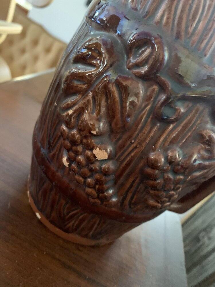 Hungarian folk ceramic pitcher with a brown glossy finish and relief decoration of vine.