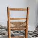 Antique wooden child's chair with a straw seat.