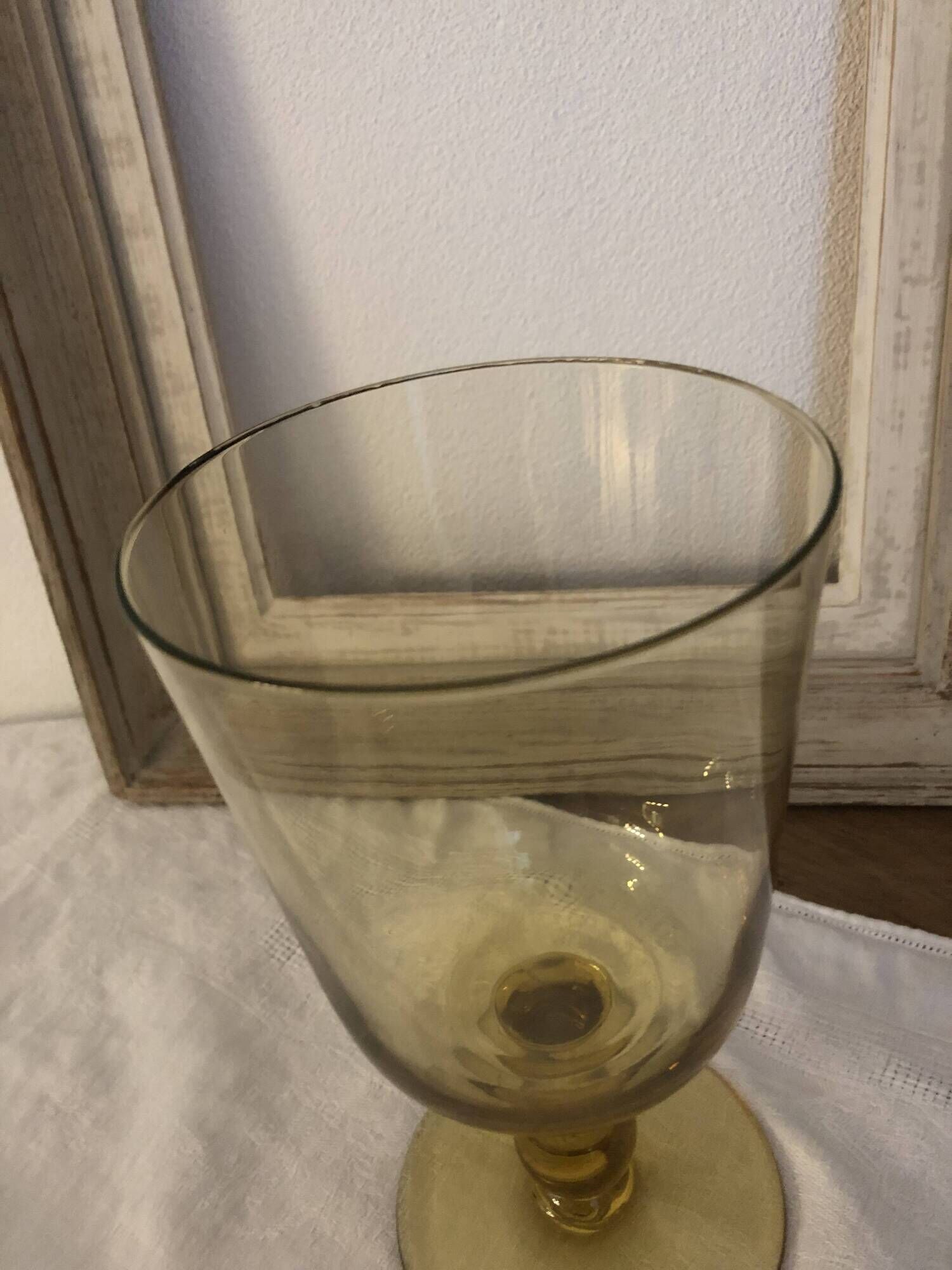 Yellow chalice vase, yellow glass vase on a pedestal.