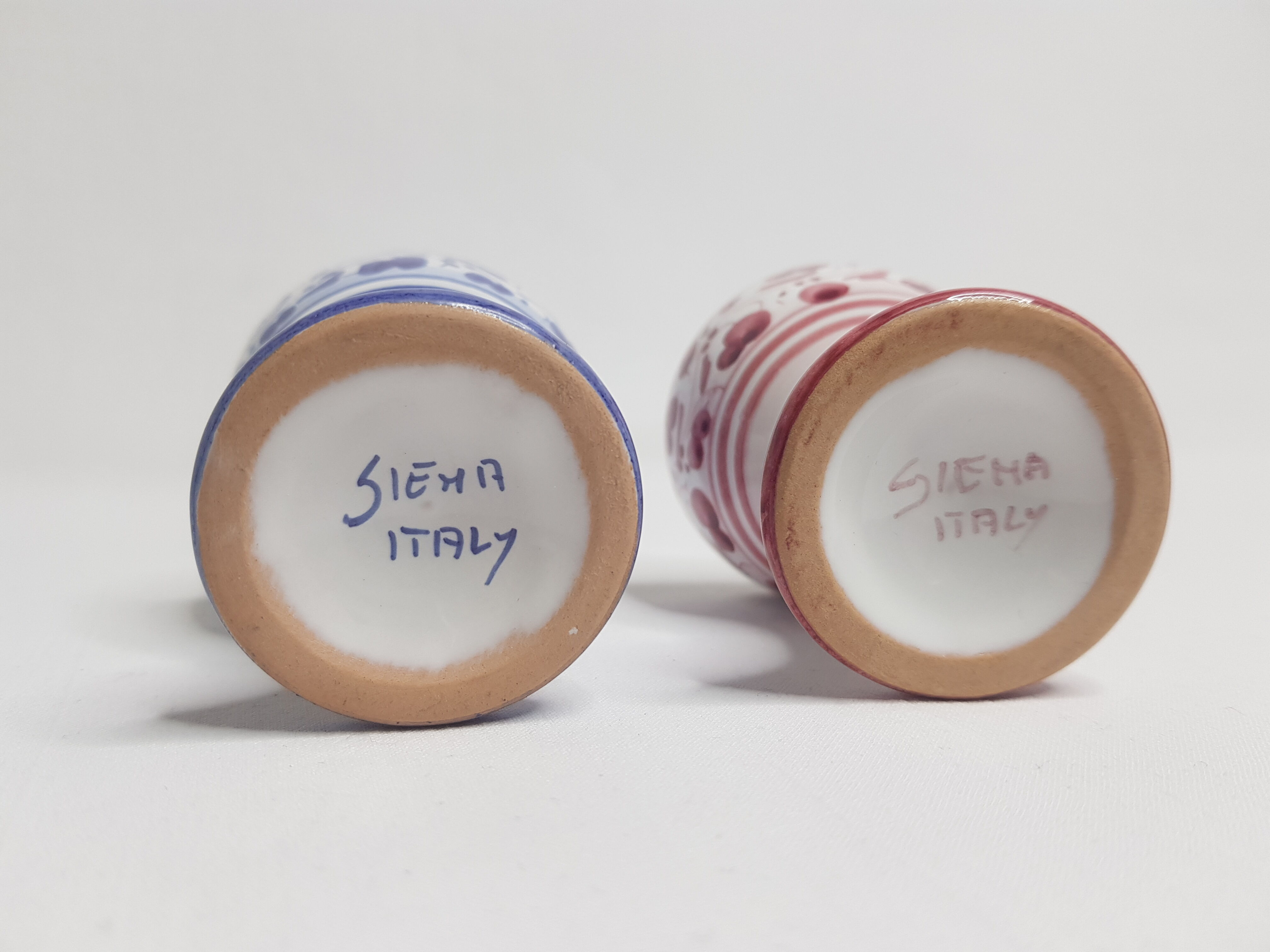 Pair of hand-decorated blue and garnet cockroaches signed "Siena Italy"