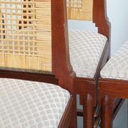 Ensemble de quatre chaises de salle à manger en rotin au design Art Déco avec dossier haut.