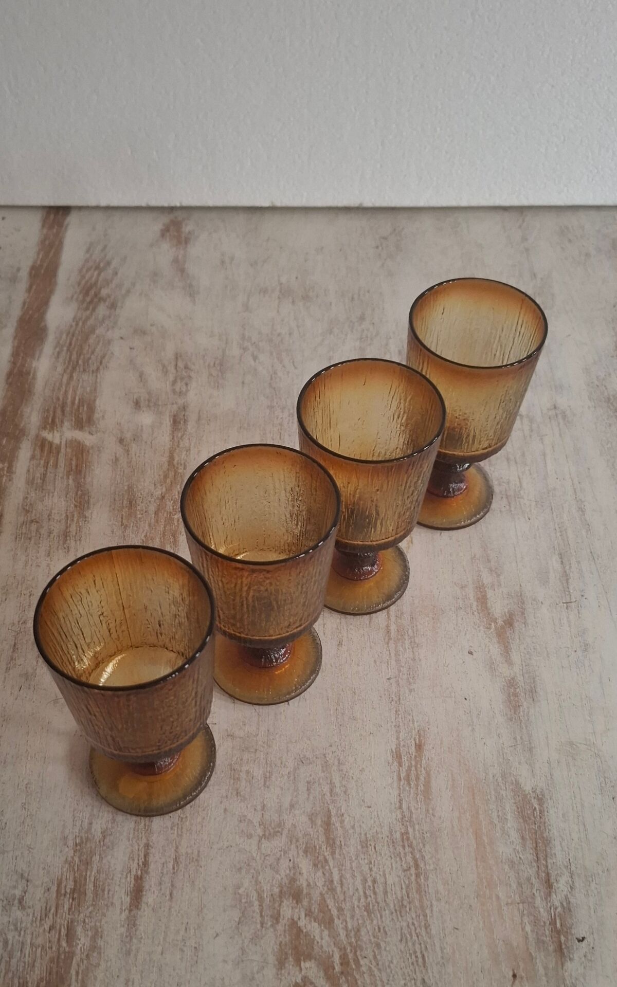 Set of four thick amber glass stemmed glasses.