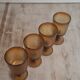 Set of four thick amber glass stemmed glasses.