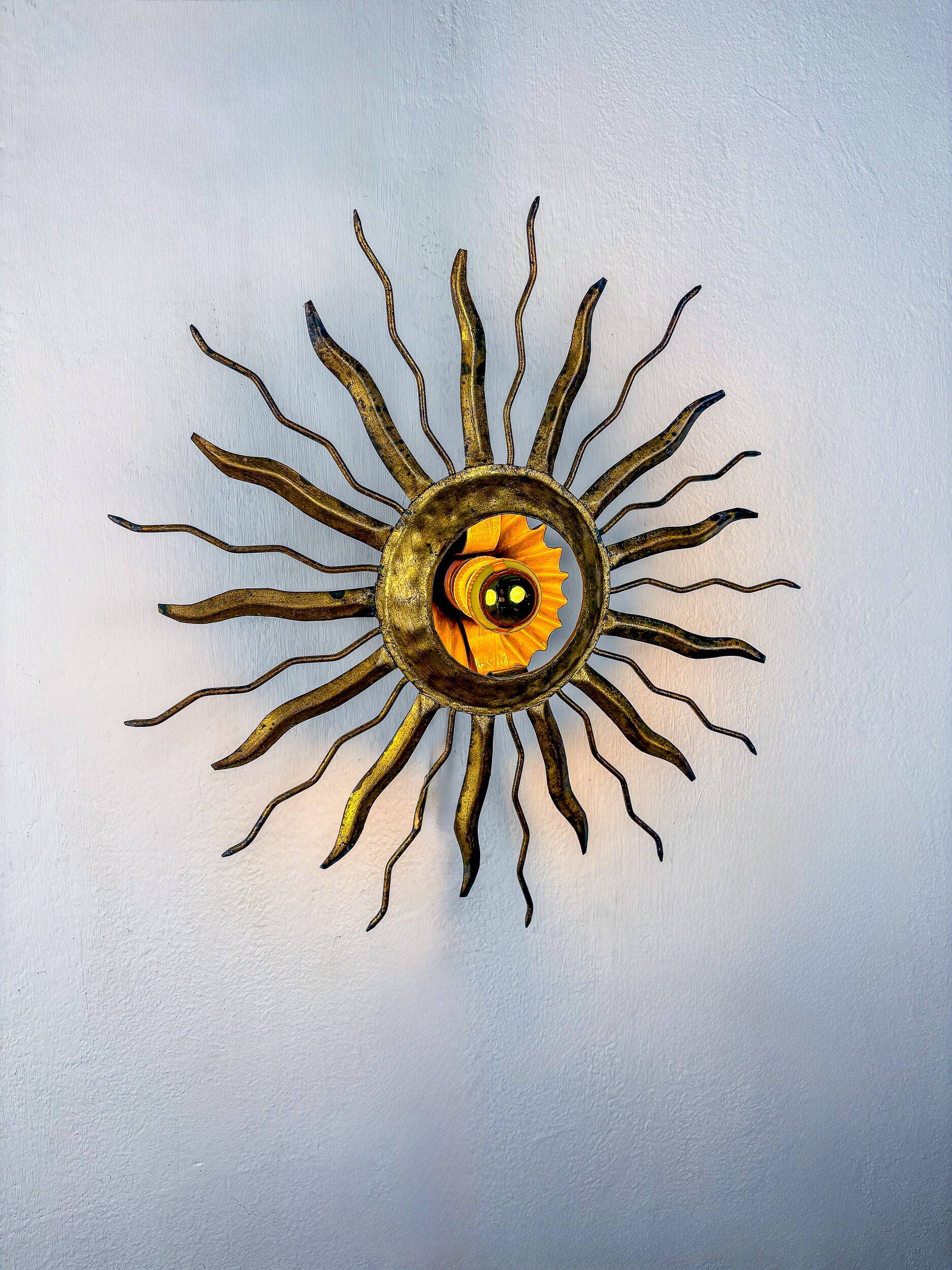 Brutalist sunburst ceiling light – gilt iron rays & exposed bulb, France, 1960s