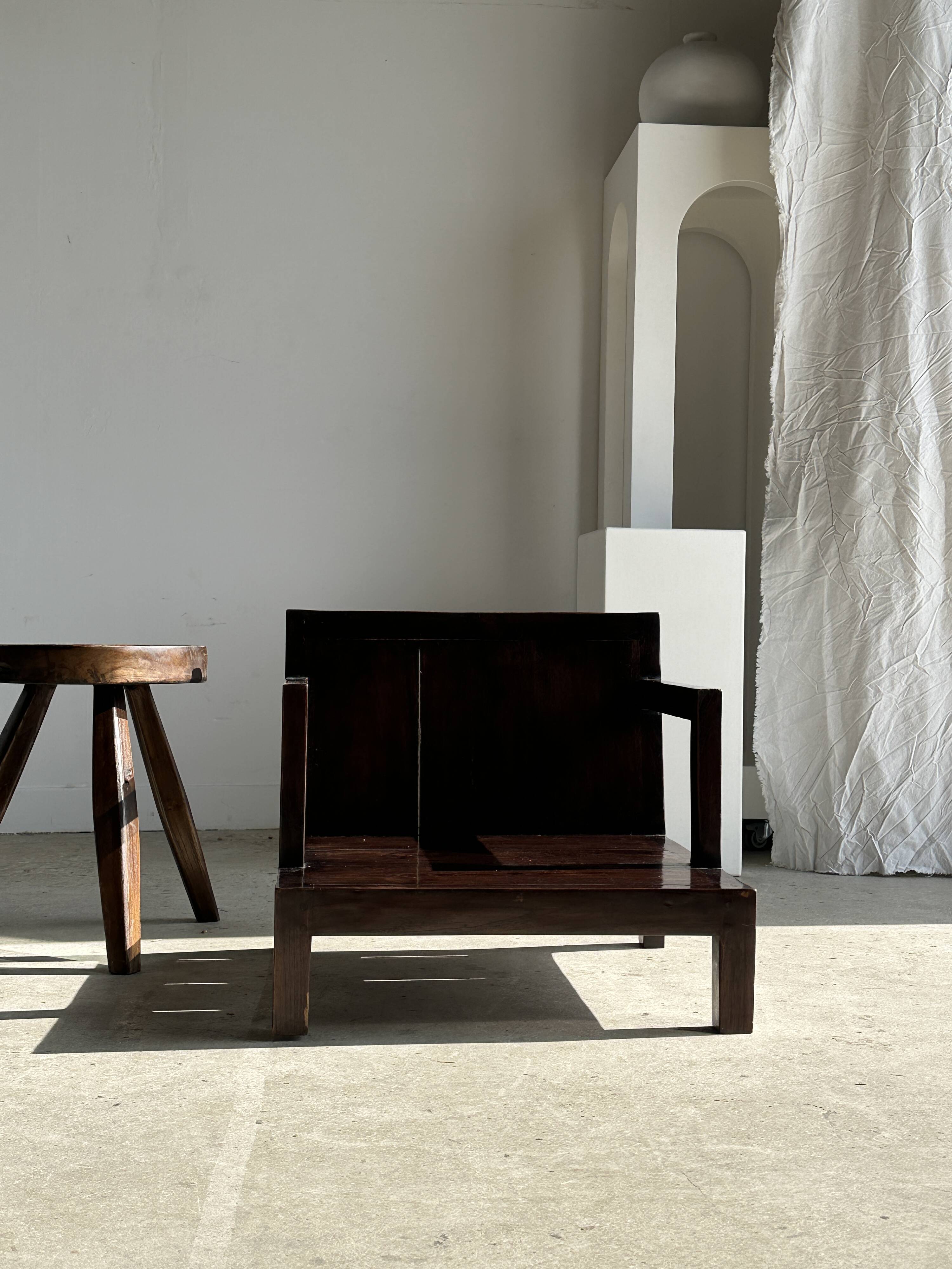 Small low armchair in varnished brown wood