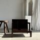 Small low armchair in varnished brown wood