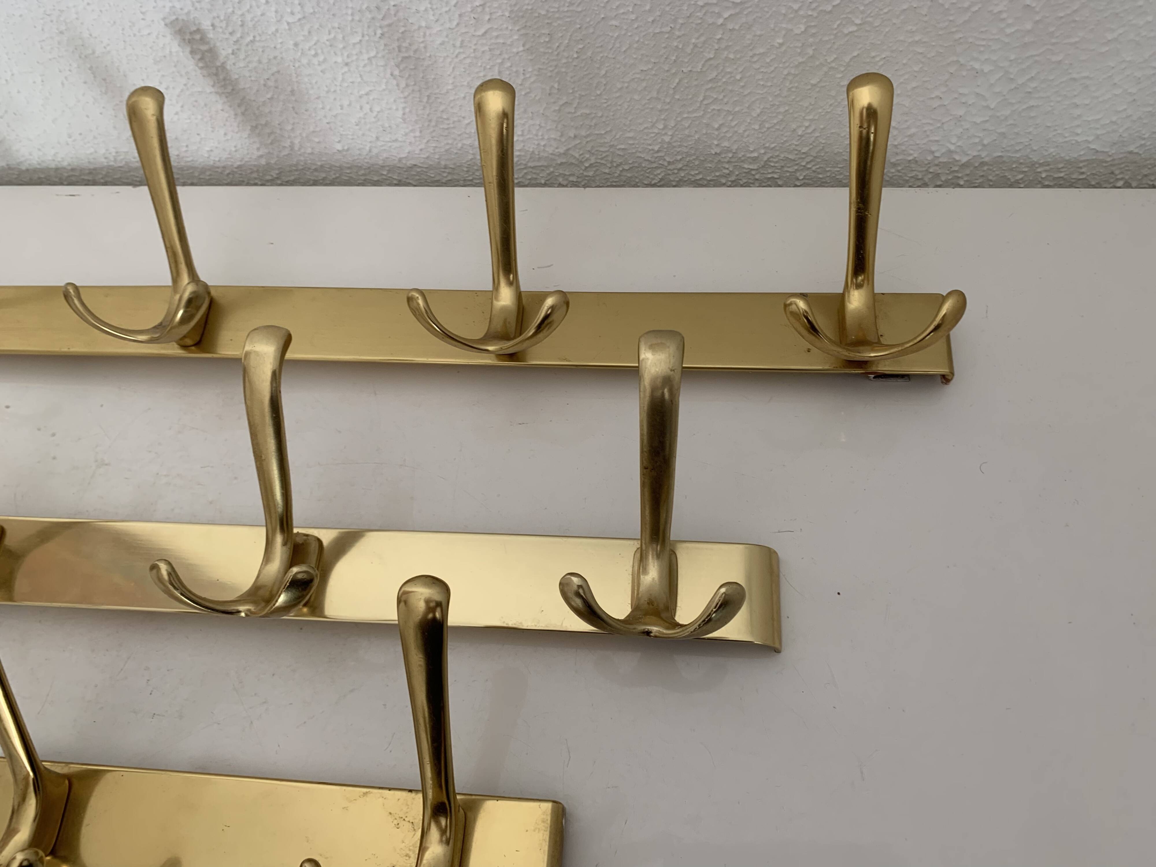 Three vintage 1960s gold coat racks with 4, 3 and 2 hooks