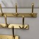 Three vintage 1960s gold coat racks with 4, 3 and 2 hooks