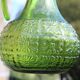 Antique vintage pitcher in green molded glass with floral relief - retro decoration